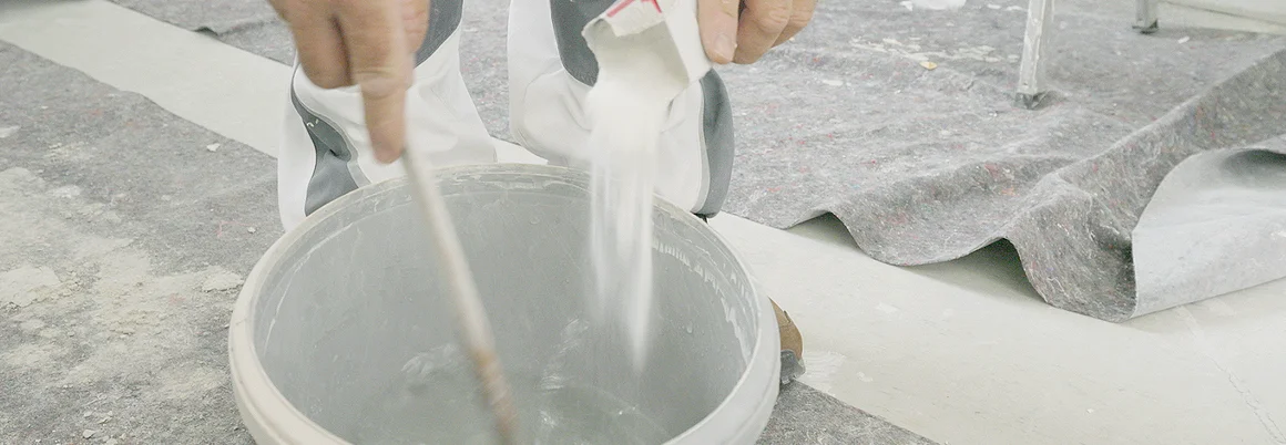 Person schüttet Pulver in Eimer